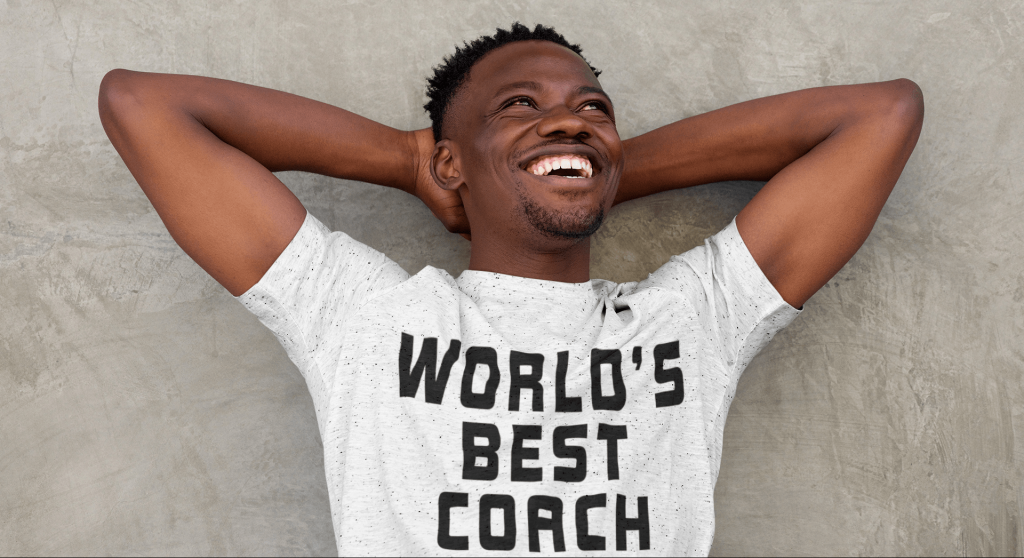 Man in "World's Best Coach" shirt